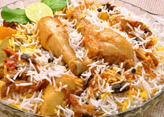 Chicken Biryani — Long-grain rice layered with spiced chicken and served with raita.